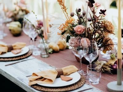Blumendekoration auf einer gedeckten Hochzeitstafel